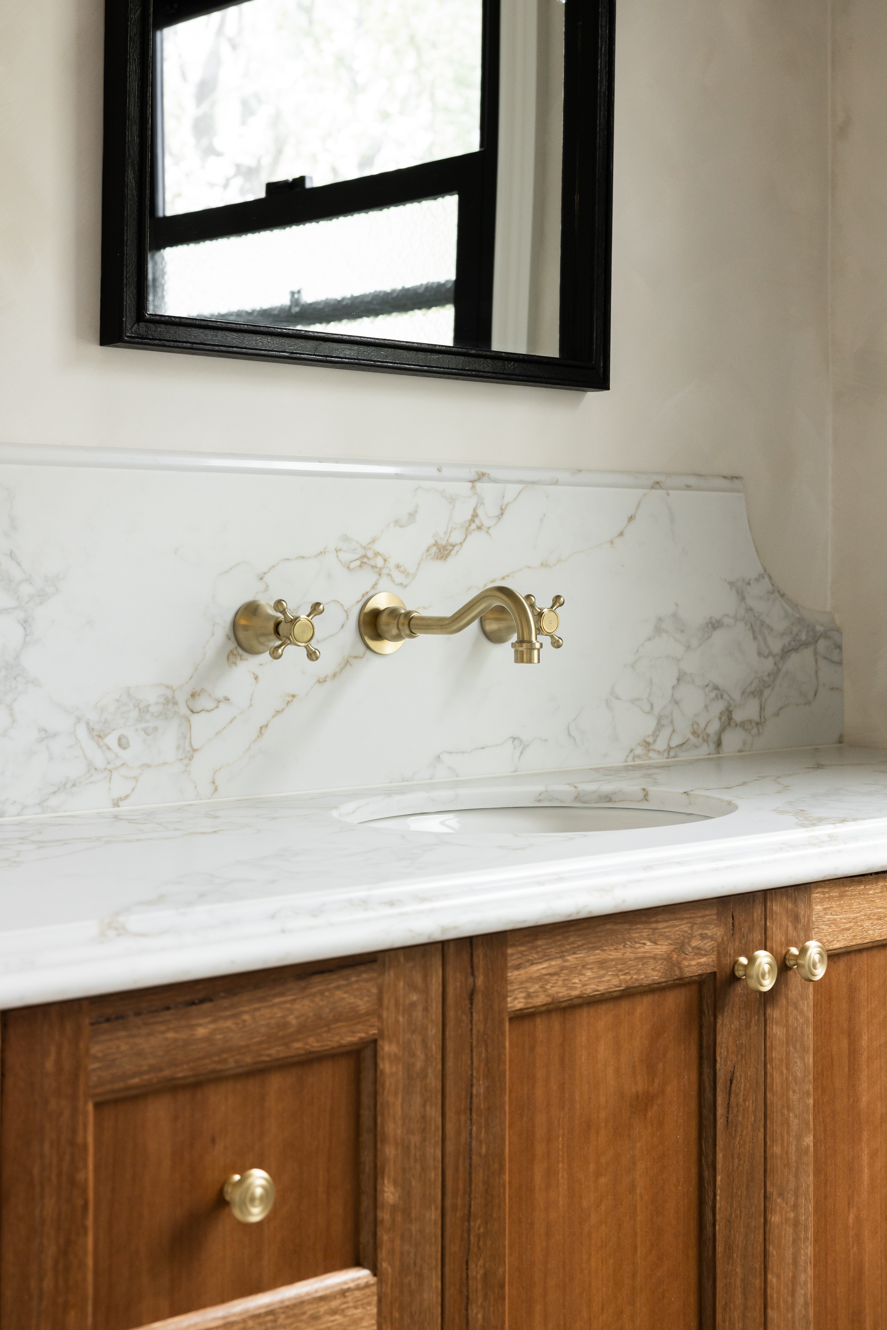 Marble vanity detail with brass cross-handle tapware