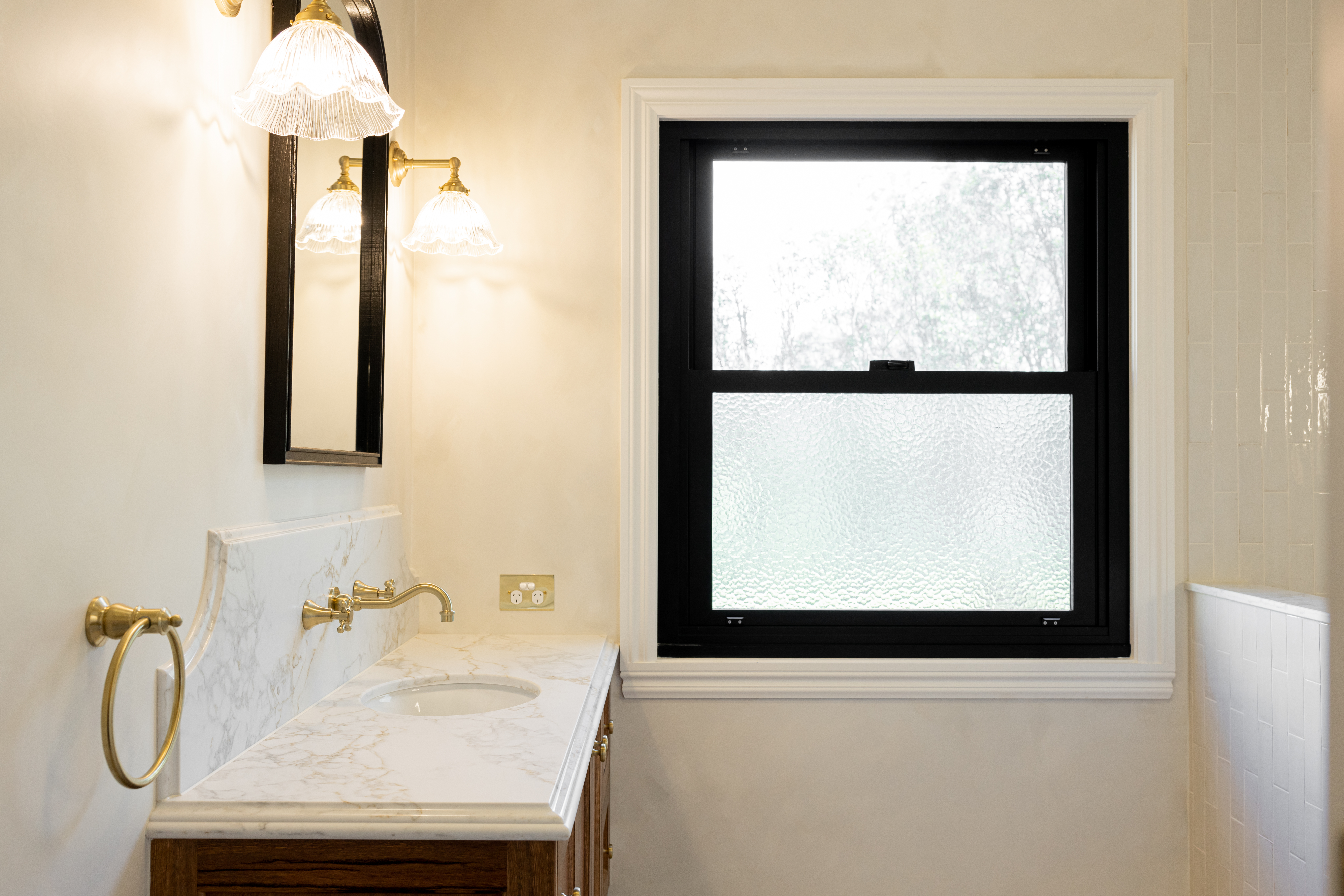 Melrose Farmhouse bathroom renovation with marble vanity, brass fixtures, and heritage-style details